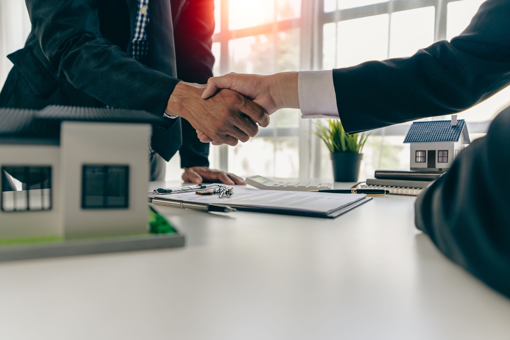 agent, lease, successful management Real estate brokerage manager shaking hands with client after signing home purchase contract in real estate agency office