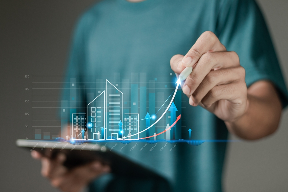 Real estate investment concept, interest rate, Investment planning, business real estate. Person touching growth graph with building icon for home mortgage and real estate analysis.